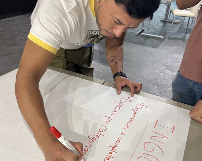 Un participante escribiendo en un papelógrafo durante una dinámica